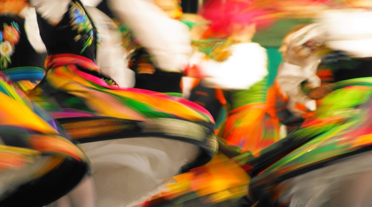 osoby tańczące w folkowych strojach, zdjęcie w ruchu, bez widocznych twarzy