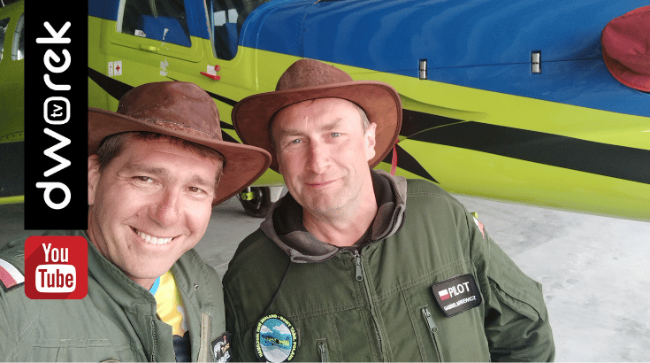 Dwóch pilotów - Tomasz Wróbel i Gabriel Batkiewicz, w tle samolot w niebiesko-żółtych barwach