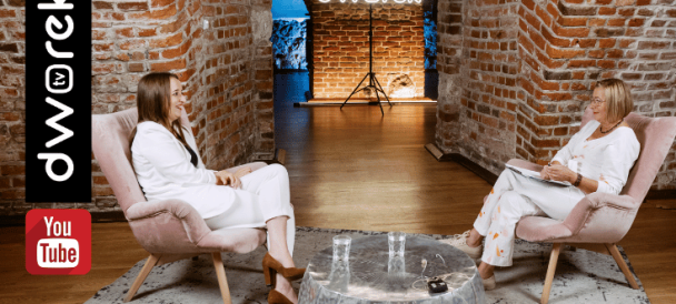 Na zdjęciu dwie kobiety w jasnych ubraniach - Renata Głowacka i Andrea Bnin-Bnińska, w studio Dworek TV z charakterystyczną murowaną ścianą, siedzą naprzeciw siebie na fotelach i rozmaiwają