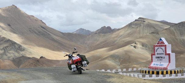 motocykl zaparkowany na szutrowej drodze w tle górzysty krajobraz Indii