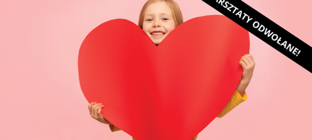 Dziewczynka trzymająca wielkie czerwone serce z kartonu.