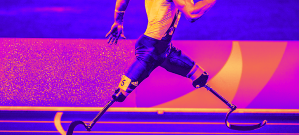 Niepełnosprawny z protezami nóg biegnie na igrzyskach olimpijskich.