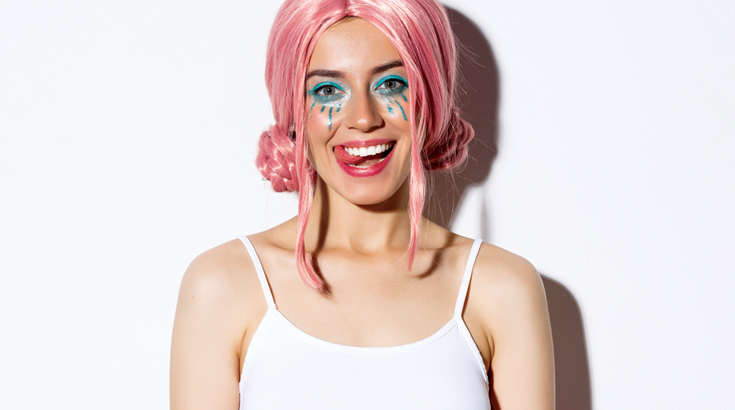 Uśmiechnięta młoda kobieta z różowymi włosami.
