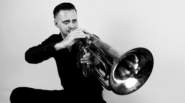 Przemysław Sokół - czarno-biała fotografia muzyka z trąbką.