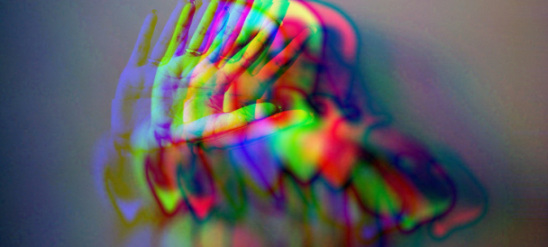 Rozmyta postać z wyciągnięta dłonią w geście STOP